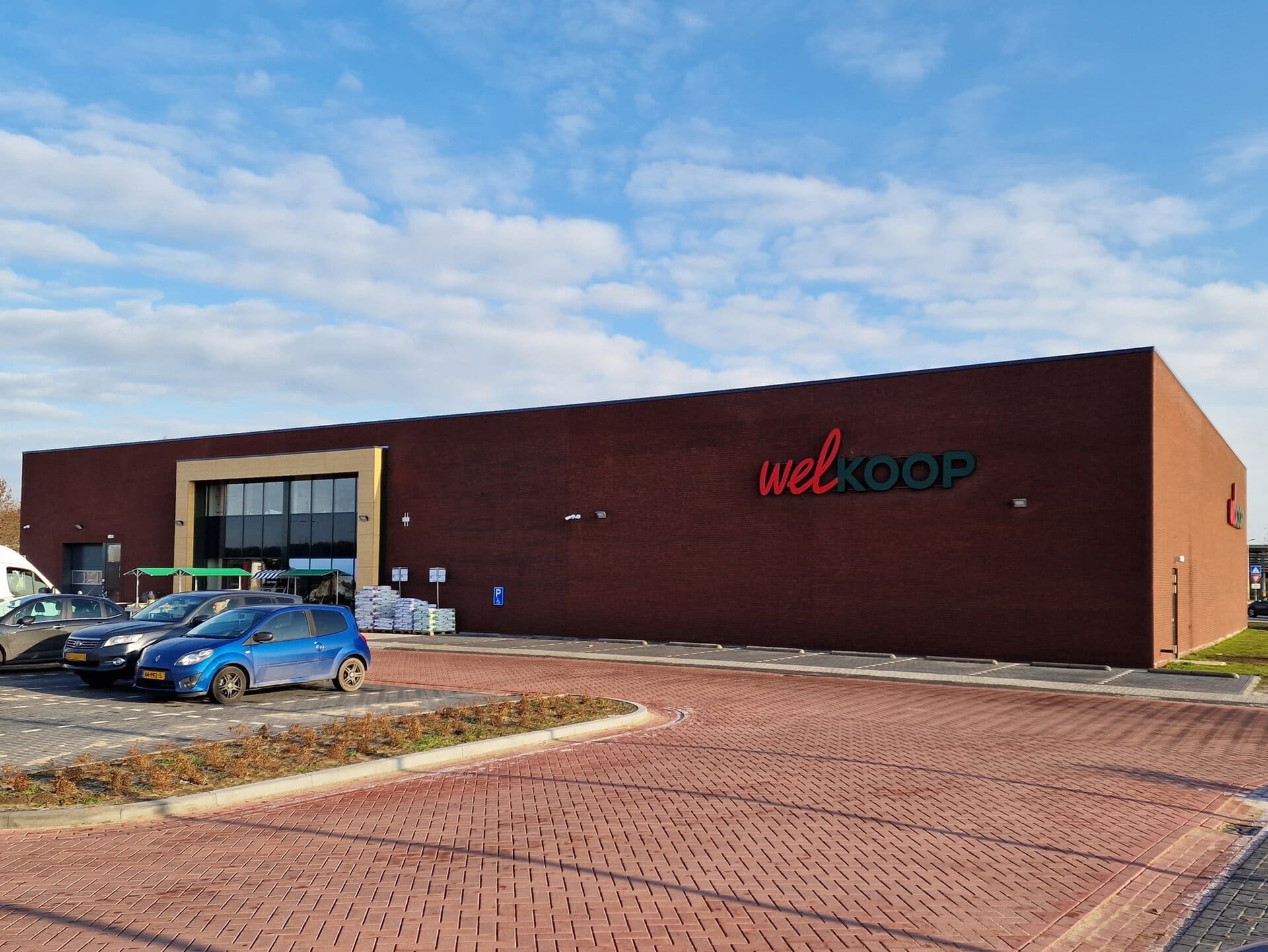 Modern Welkoop winkelgebouw in Geldermalsen met parkeerplaats.