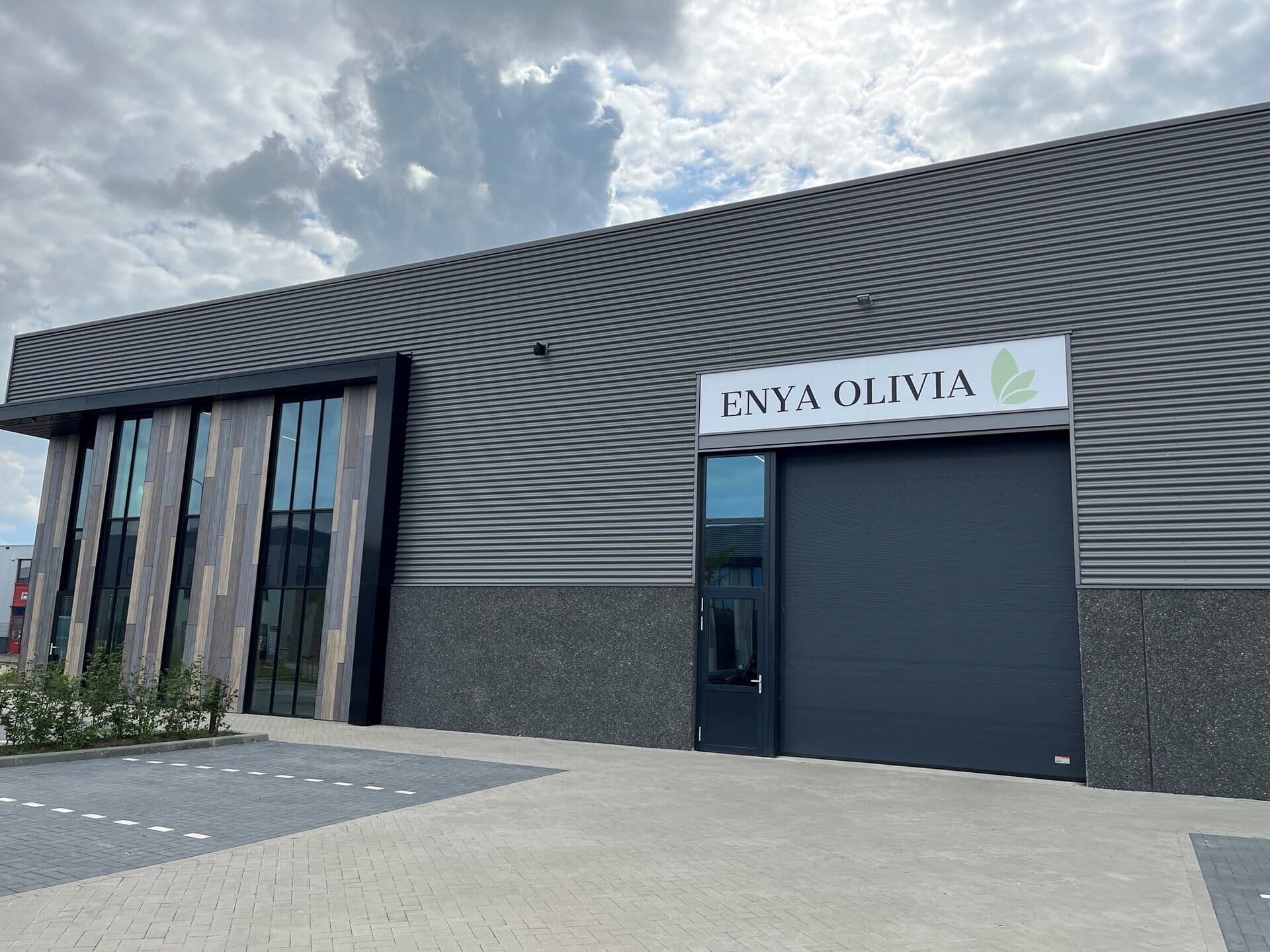 Moderne bedrijfsruimte met grote ramen en bedrijfsnaam ENYA OLIVIA.