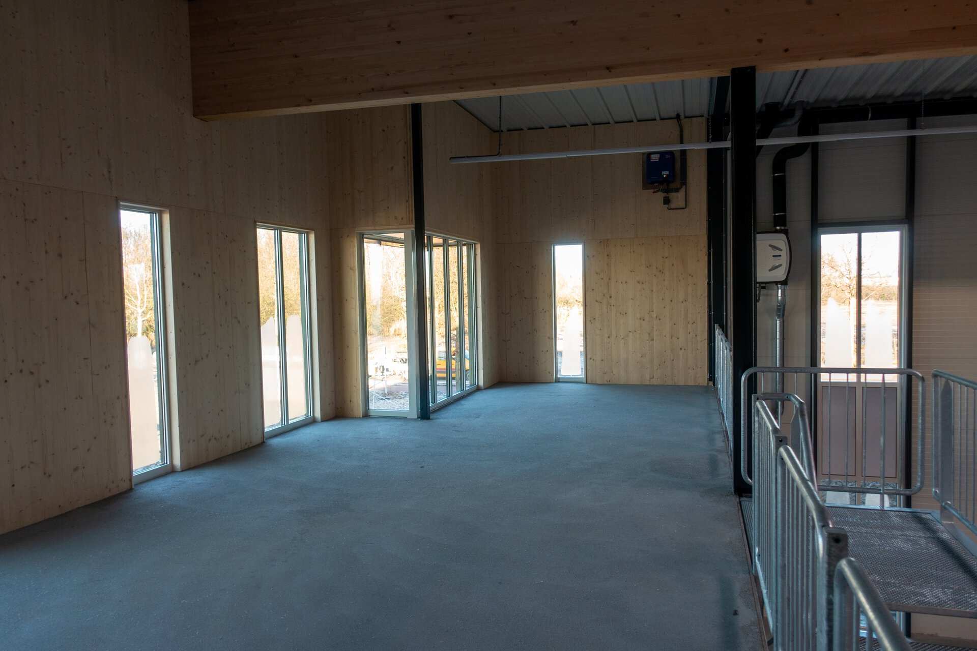 Moderne bedrijfsruimte met grote ramen en houten wanden.