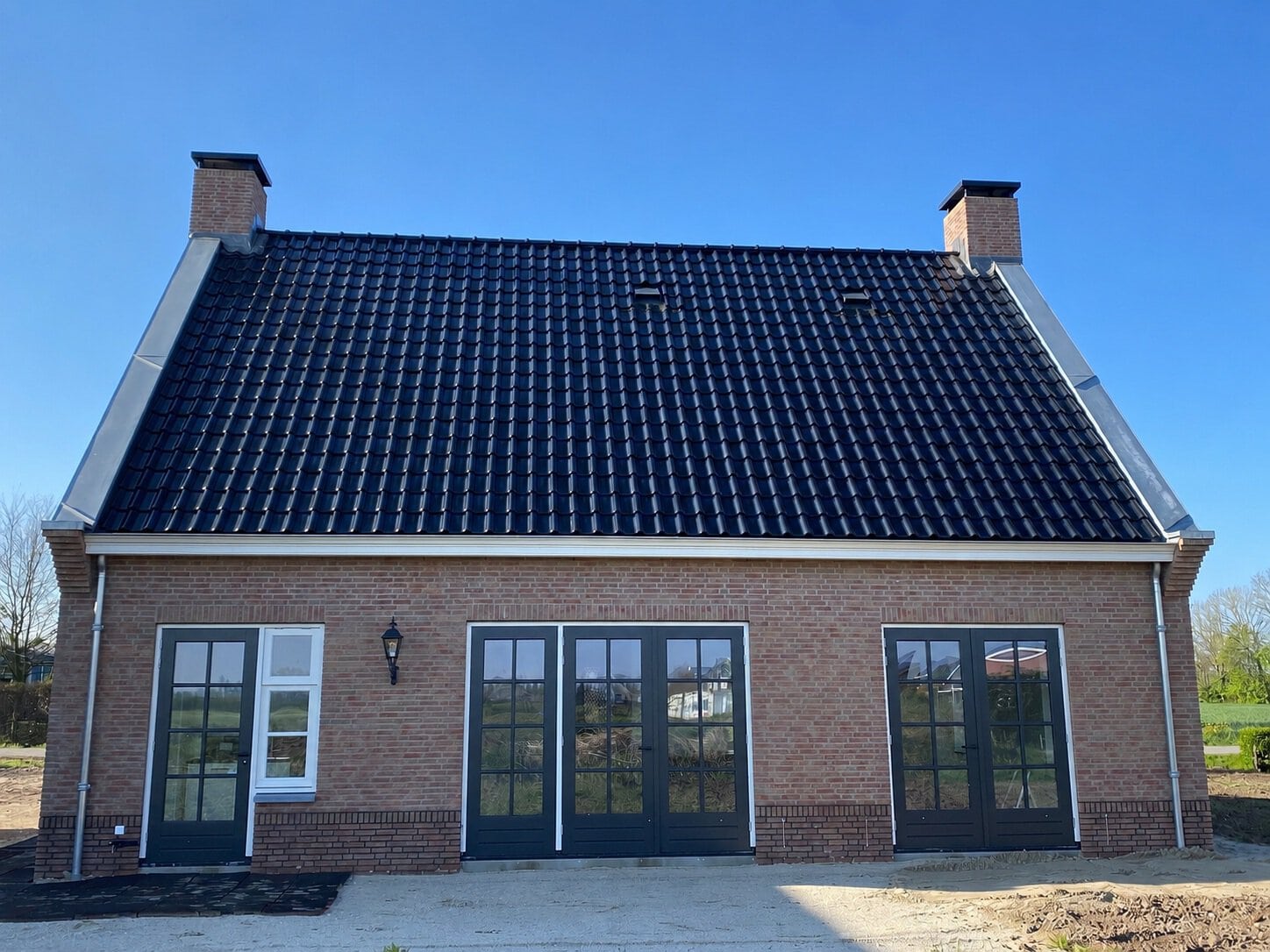 Moderne notariswoning met bijgebouw en grote ramen.